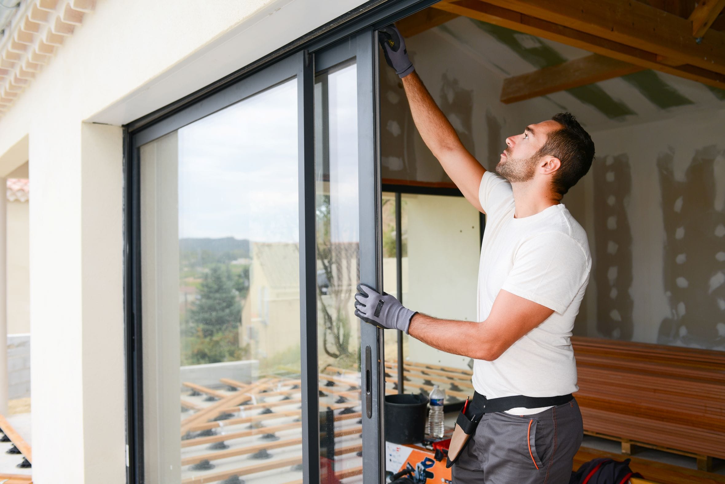 Worker Installing Glass Sliding Doors Worker Installing Glass Sliding Doors