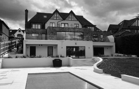 Black and white shot of house from poolside